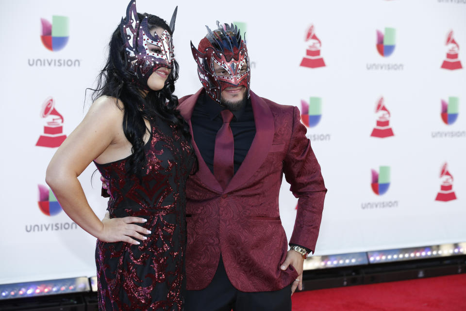 El luchador profesional Kalisto, derecha, y su esposa Abigail Rodriguez llegan a los Latin Grammy el jueves 15 de noviembre de 2018 en el MGM Grand Garden Arena en Las Vegas. (Foto Eric Jamison/Invision/AP)