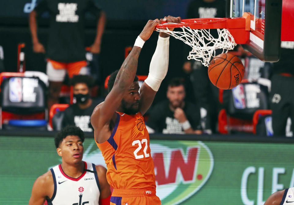 Phoenix Suns center Deandre Ayton (22) dunks the ball as Washington Wizards forward Rui Hachimura looks on during the second half of an NBA basketball game Friday, July 31, 2020, in Lake Buena Vista, Fla. (Kim Klement/Pool Photo via AP)