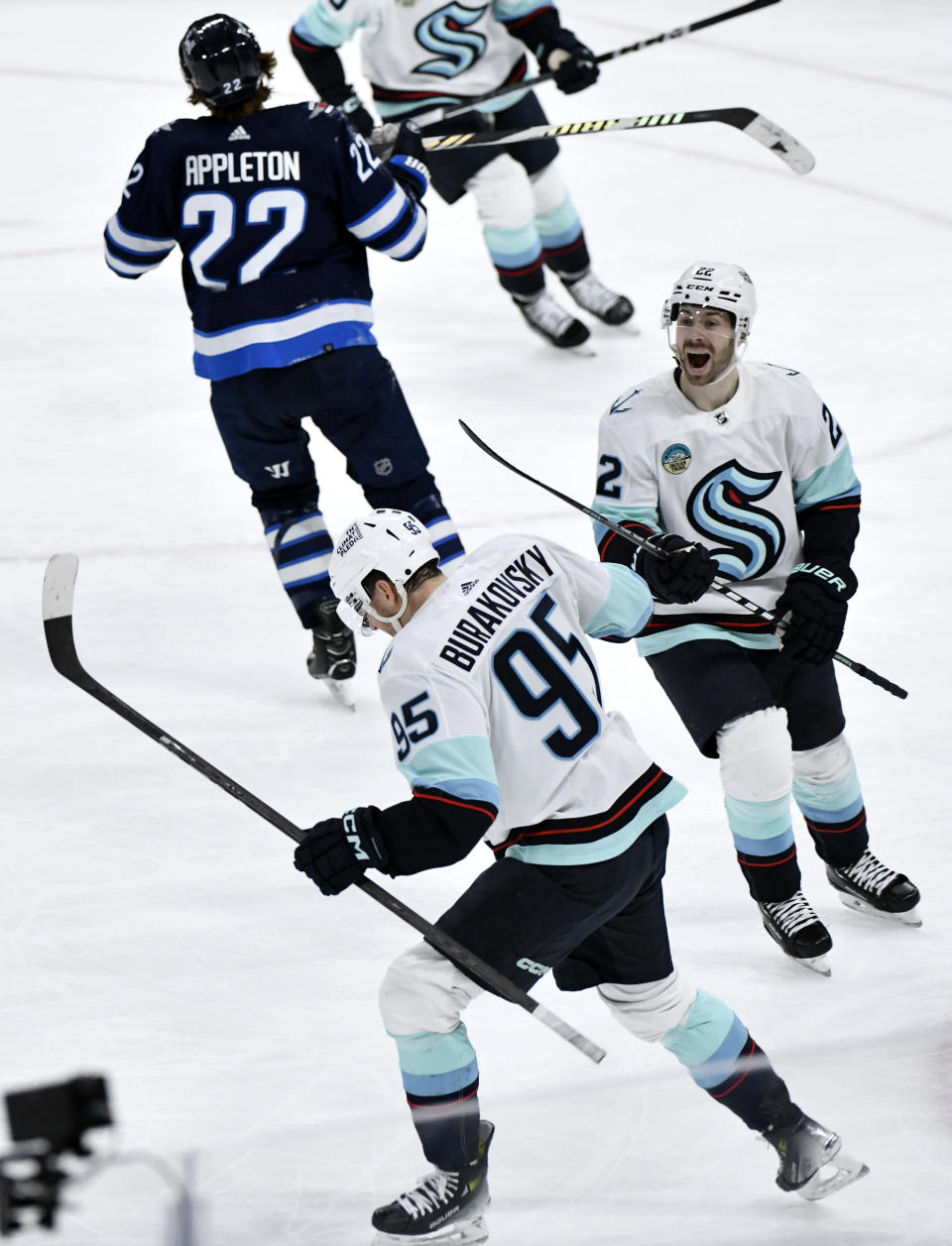 Seattle Kraken's Andre Burakovsky (95) celebrates his goal against the Winnipeg Jets with Oliver Bjorkstrand (22) during the third period of an NHL hockey game Tuesday, March 5, 2024, in Winnipeg, Manitoba. (Fred Greenslade/The Canadian Press via AP)