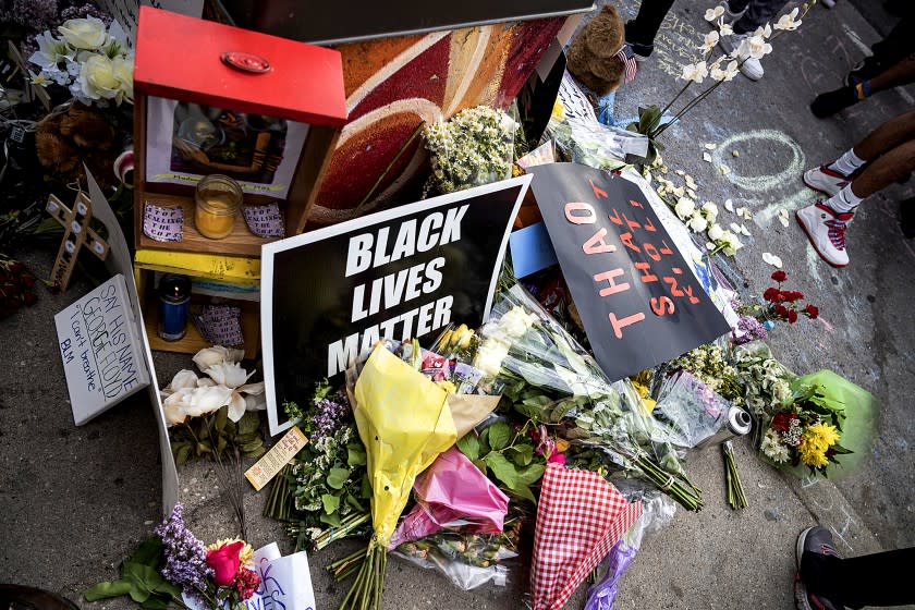 Items are left in honor George Floyd during a protest Tuesday, May 26, 2020, in Minneapolis. Four Minneapolis officers involved in the arrest of Floyd, a black man who died in police custody, were fired Tuesday, hours after a bystander's video showed an officer kneeling on the handcuffed man's neck, even after he pleaded that he could not breathe and stopped moving. (Richard Tsong-Taatarii/Star Tribune via AP)