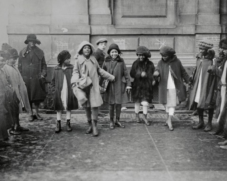 Photo of a group of young Black girls playing after school in Harlem in 1925.