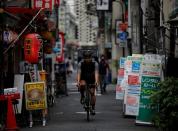 Takenobu Tonegawa cycles as he works his part-time job as Uber Eats delivery person amid the coronavirus disease (COVID-19) outbreak, in Tokyo