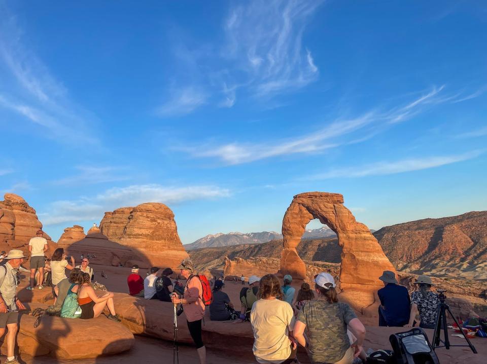 Crowds of people at the delicate arch at Arches National Park.