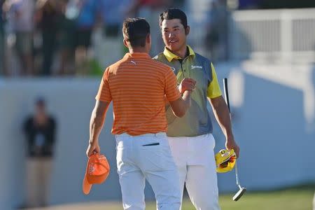 Feb 7, 2016; Scottsdale, AZ, USA; Hideki Matsuyama shakes hands with Rickie Fowler (back to camera) after the final round of the Waste Management Phoenix Open golf tournament at TPC Scottsdale. Matsuyama won after a three-hole playoff. Joe Camporeale-USA TODAY Sports