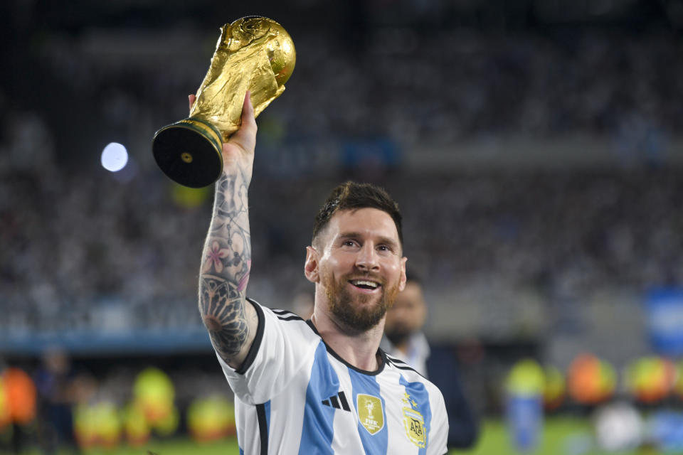 Argentina's Lionel Messi hoists the FIFA World Cup trophy during a celebration ceremony for local fans after an international friendly soccer match against Panama at the Monumental stadium in Buenos Aires, Argentina, Thursday, March 23, 2023. (AP Photo/Gustavo Garello)