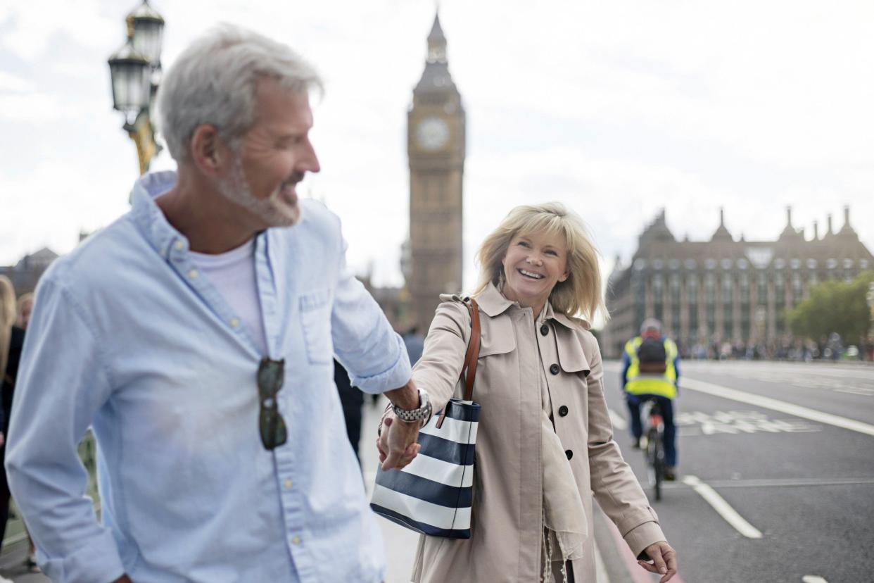 mature couple in London walking on westminster bridge