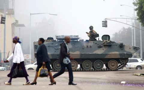 Armoured personnel carriers are stationed at major junctions in Harare as residents attempt to continue with their daily lives under the spectre of an alleged coup - Credit: AP