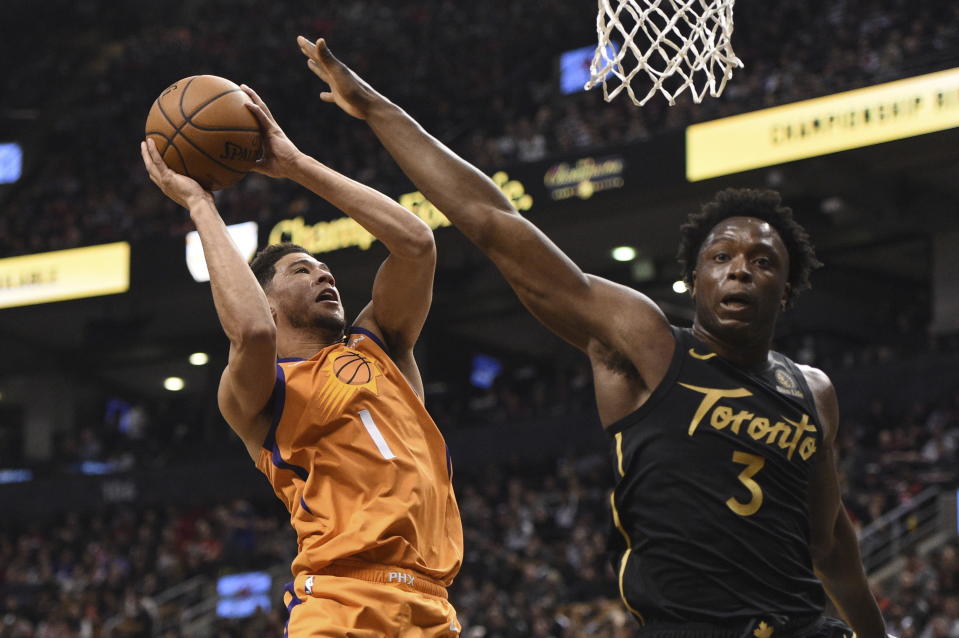 Phoenix Suns guard Devin Booker (1) shoots as Toronto Raptors forward OG Anunoby (3) defends during the first half of an NBA basketball game Friday, Feb. 21, 2020, in Toronto. (Frank Gunn/The Canadian Press via AP)