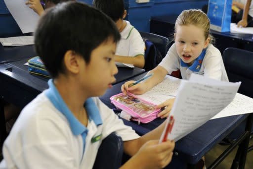 Happy Rogers (R), the daughter of US investor Jim Rogers, discusses her Mandarin examination paper with her classmate at Nanyang Primary School in Singapore in 2011. As far back as 25 years ago, Rogers already believed China would be the next economic superpower and young people the world over should prepare for the future by learning Mandarin