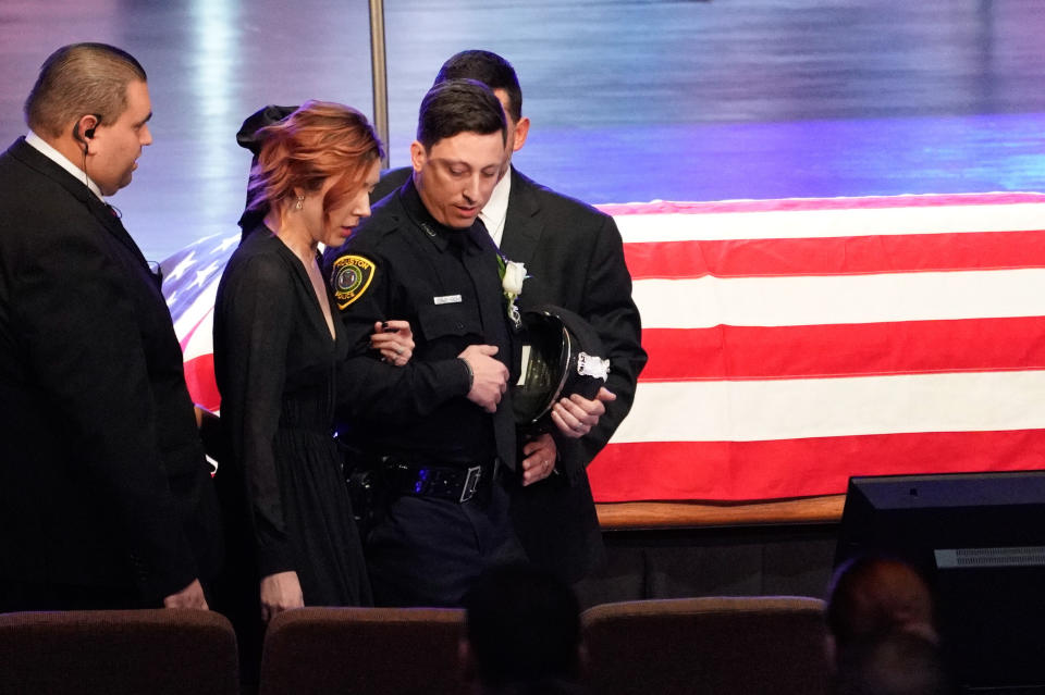 Widow Bethany Elise Brewster is escorted into the church sanctuary for the funeral of her husband, Houston Police Sgt. Christopher Brewster, Thursday, Dec. 12, 2019, at Grace Church Houston in Houston. Brewster, 32, was gunned down Saturday evening, Dec. 7, while responding to a domestic violence call in Magnolia Park. Police arrested 25-year-old Arturo Solis that night in the shooting death. Solis faces capital murder charges. (Melissa Phillip/Houston Chronicle via AP, Pool)