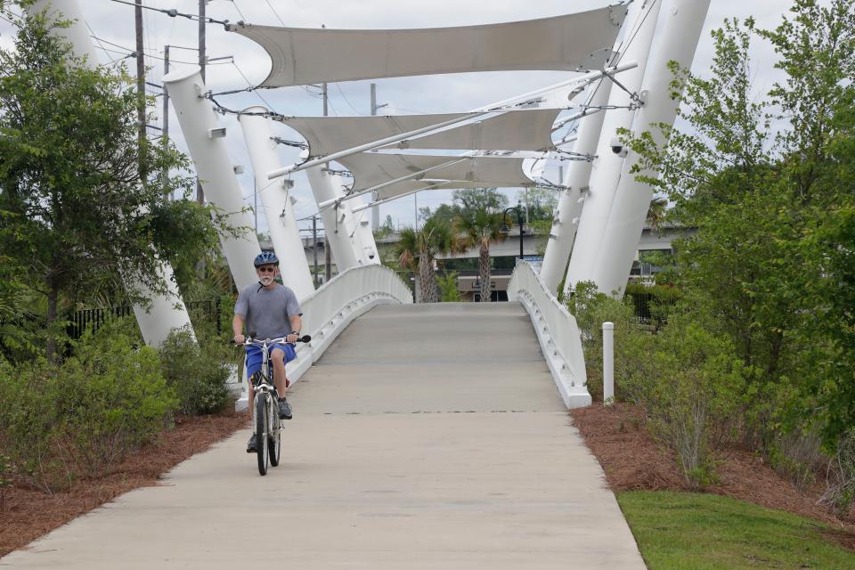 A man rides his bike across the Capital Cascades Crossing Bridge at Cascades Park Friday, April 26, 2019. 