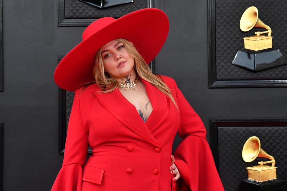 Elle King at an event wearing a wide-brimmed hat and bell-sleeved outfit