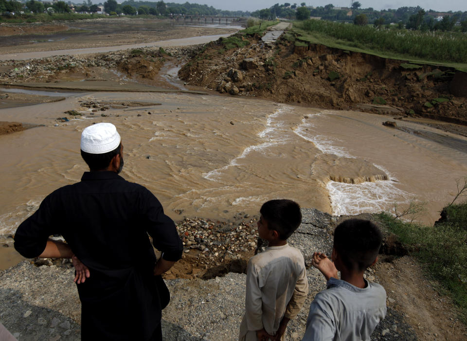 People examine a damaged canal washed away by an earthquake, in Jatlan near Mirpur, in northeast Pakistan, Wednesday, Sept. 25, 2019. Thousands of people whose homes were damaged because of a strong earthquake are desperately waiting for the arrival of government help, 22 hours after the 5.8 magnitude tremor struck Pakistan-held Kashmir and elsewhere, killing 25 people and injuring 700. (AP Photo/Anjum Naveed)