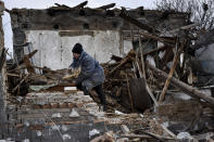 Inna, 71, clears the rubble after her house was destroyed by a Russian drone attack in a residential neighbourhood, in Zaporizhzhia, Ukraine, on Thursday, March 28, 2024. (AP Photo/Andriy Andriyenko)