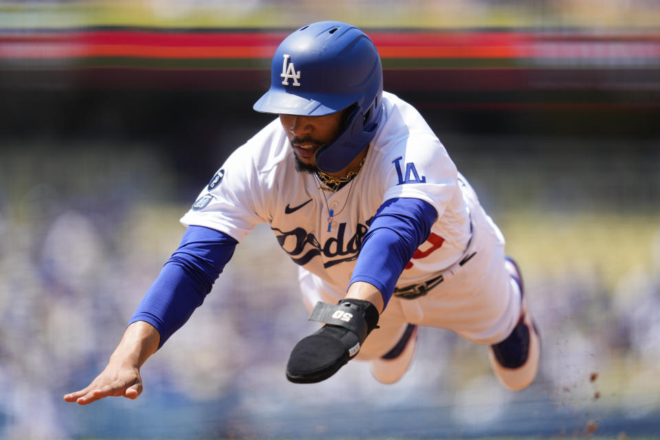 Los Angeles Dodgers' Mookie Betts (50) dives back to first base safely during the third inning of a baseball game against the Arizona Diamondbacks Sunday, July 11, 2021, in Los Angeles. (AP Photo/Ashley Landis)