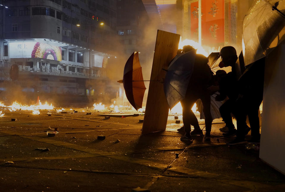 Protestors react as police fire tear gas in the Kowloon area of Hong Kong, Nov. 18, 2019. (Photo: Vincent Yu/AP)