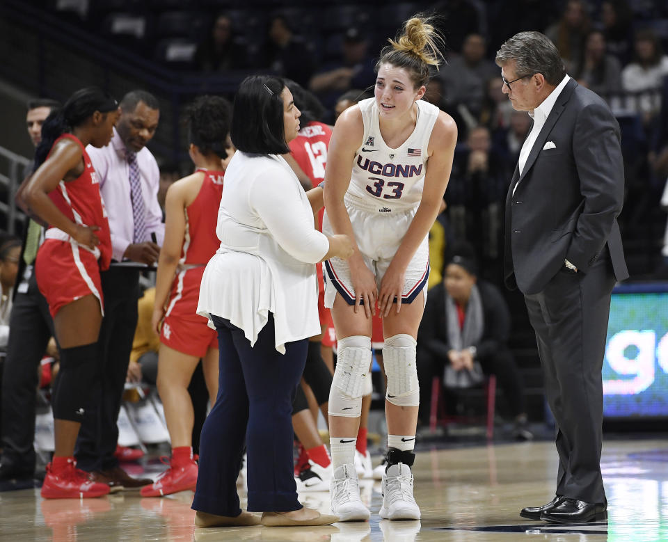 Connecticut head coach Geno Auriemma, right, and trainer Janelle Francisco, left, look at Connecticut's Katie Lou Samuelson after a hard fall to the court during the first half of an NCAA college basketball game against Houston, Saturday, March 2, 2019, in Storrs, Conn. (AP Photo/Jessica Hill)