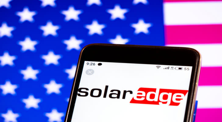 SolarEdge logo on phone with American flag background. SEDG stock