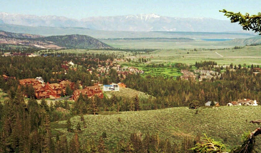 FILE - This July 10, 1995 file photo shows the resort community of Mammoth Lakes, Calif., with the Long Valley caldera seen in the far distance. Researchers say nearly 200,000 people live, work or pass through California's volcanic hazard zones on a daily basis, and there's a 16 percent probability of an eruption in the next 30 years. A study released Monday, Feb. 25, 2019 by the U.S. Geological Survey attempts to characterize the exposure of population, infrastructure, resources and the economy from an eruption in any of eight areas statewide that are designated as having moderate, high or very high threat. (AP Photo/Bob Galbraith, File)