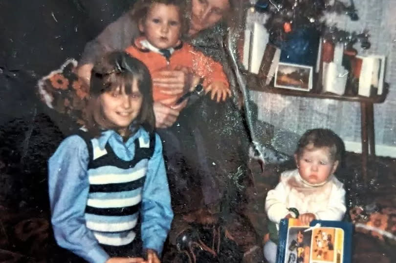 Sandy sitting on his Dad's knee, with his Auntie and sister Donna sitting on the floor -Credit:police scotland