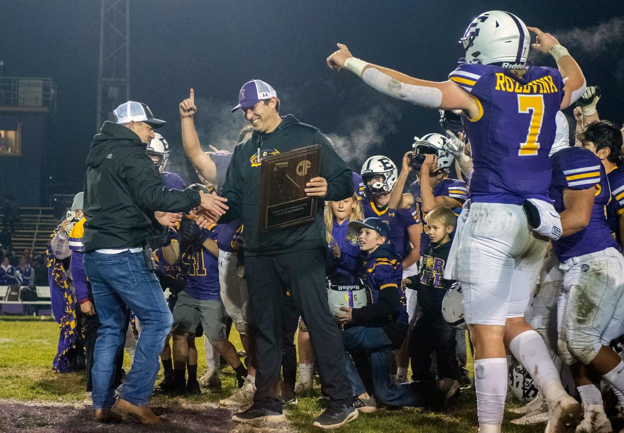 Escalon head coach Andrew Beam is handed the winning plaque after the his team defeated Pleasant Valley 42-20 in the CIF Division 4-AA Norcal Championship football at Escalon on Friday, Dec. 2, 2022 