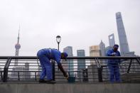 Workers paint at the Bund in front of Lujiazui financial district of Pudong, Shanghai