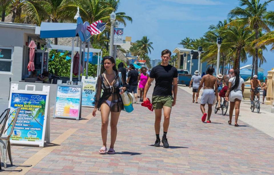 Tourists and beachgoers walk along the Hollywood beach Broadwalk on Aug. 16, 2023. A stretch of it could be dramatically revamped, if the city approves developers’ plans to build an 18-story condo and apartment tower complex, a beach club and restaurant.