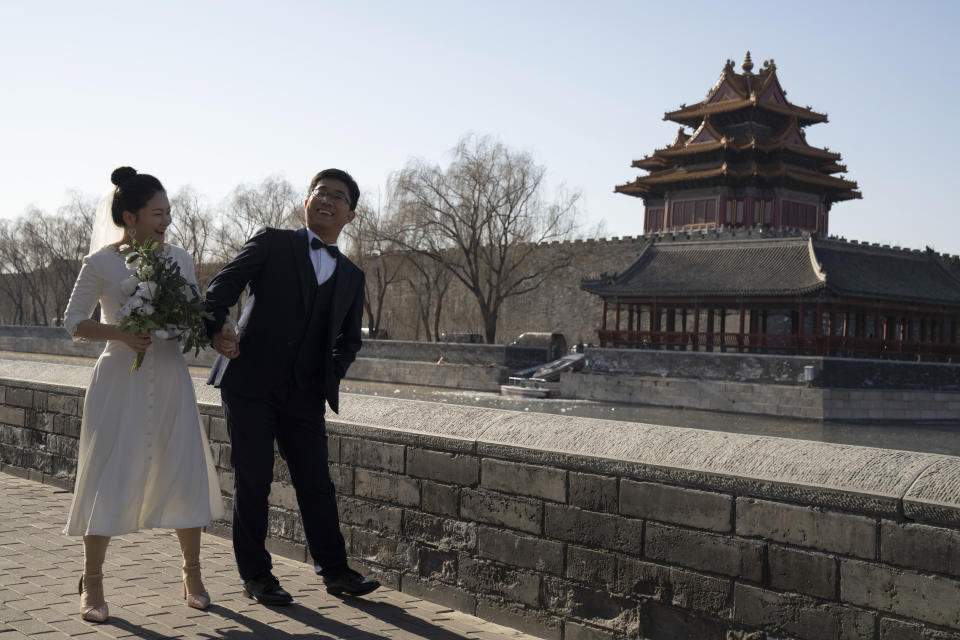Groom Dong Yangfeng and bride Wang Sai pose for photos near the Forbidden City in Beijing on Sunday, Dec. 20, 2020. Lovebirds in China are embracing a sense of normalcy as the COVID pandemic appears to be under control in the country where it was first detected. (AP Photo/Ng Han Guan)
