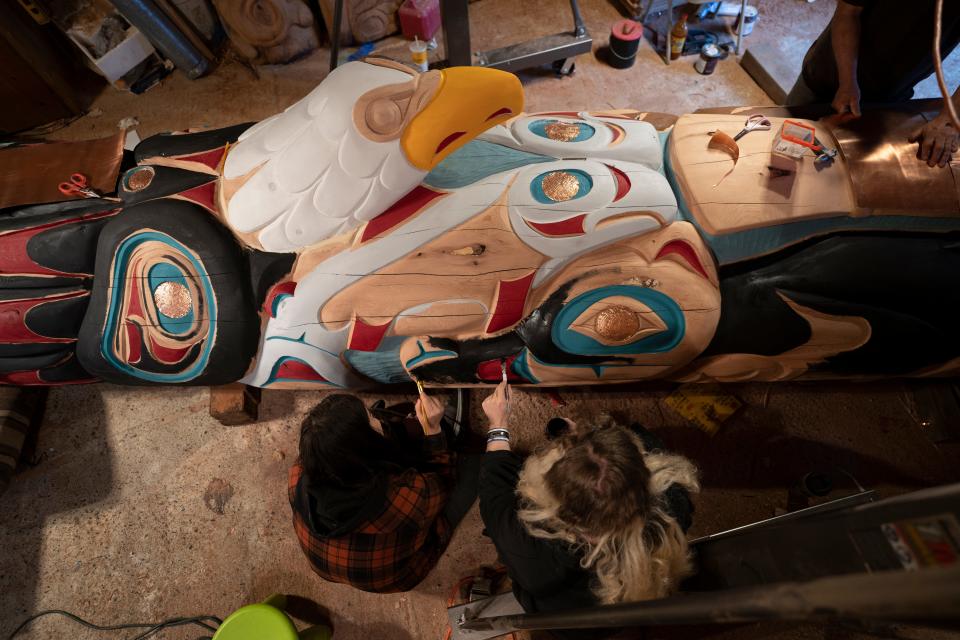 Two Lummi nation House of Tears Carvers artisans work on the 25-foot totem pole that is journeying across the U.S. with Native American activists to highlight the need to protect sacred lands.