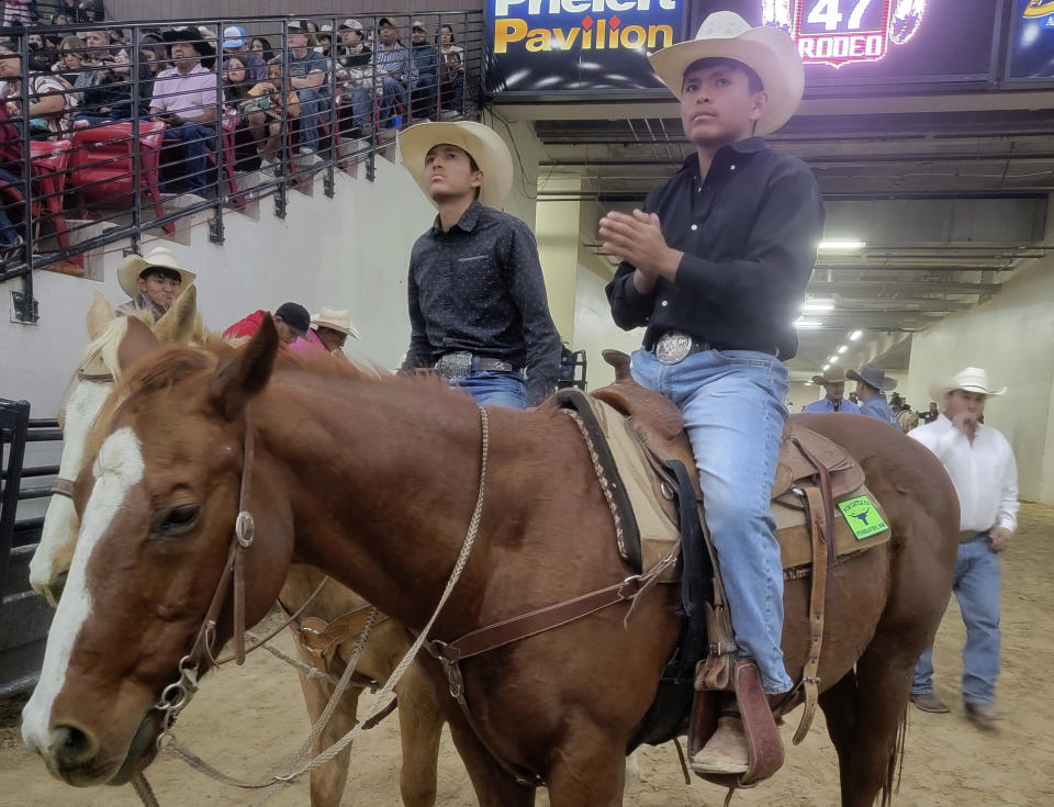 In this undated photo provided by Tyrone Tsosie, Tyrone Tsosie and his son, Tydon Tsosie, right, compete in the Indian National Finals Rodeo in Las Vegas. Born out of necessity and in mastering skills that came as horses transformed hunting, travel and warfare, rodeo has remained popular in Native American communities. Grandstands often play host to mini family reunions while Native cowboys and cowgirls show off their skills roping, riding and wrestling livestock. It's a lifestyle that's connected to nature and community. (Tyrone Tsosie via AP)