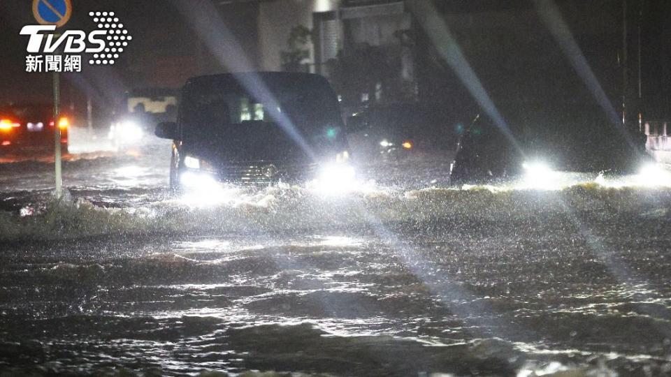 日本各地降下破紀錄豪雨，車輛在夜間開在一片汪洋洪水中。（圖／達志影像美聯社）