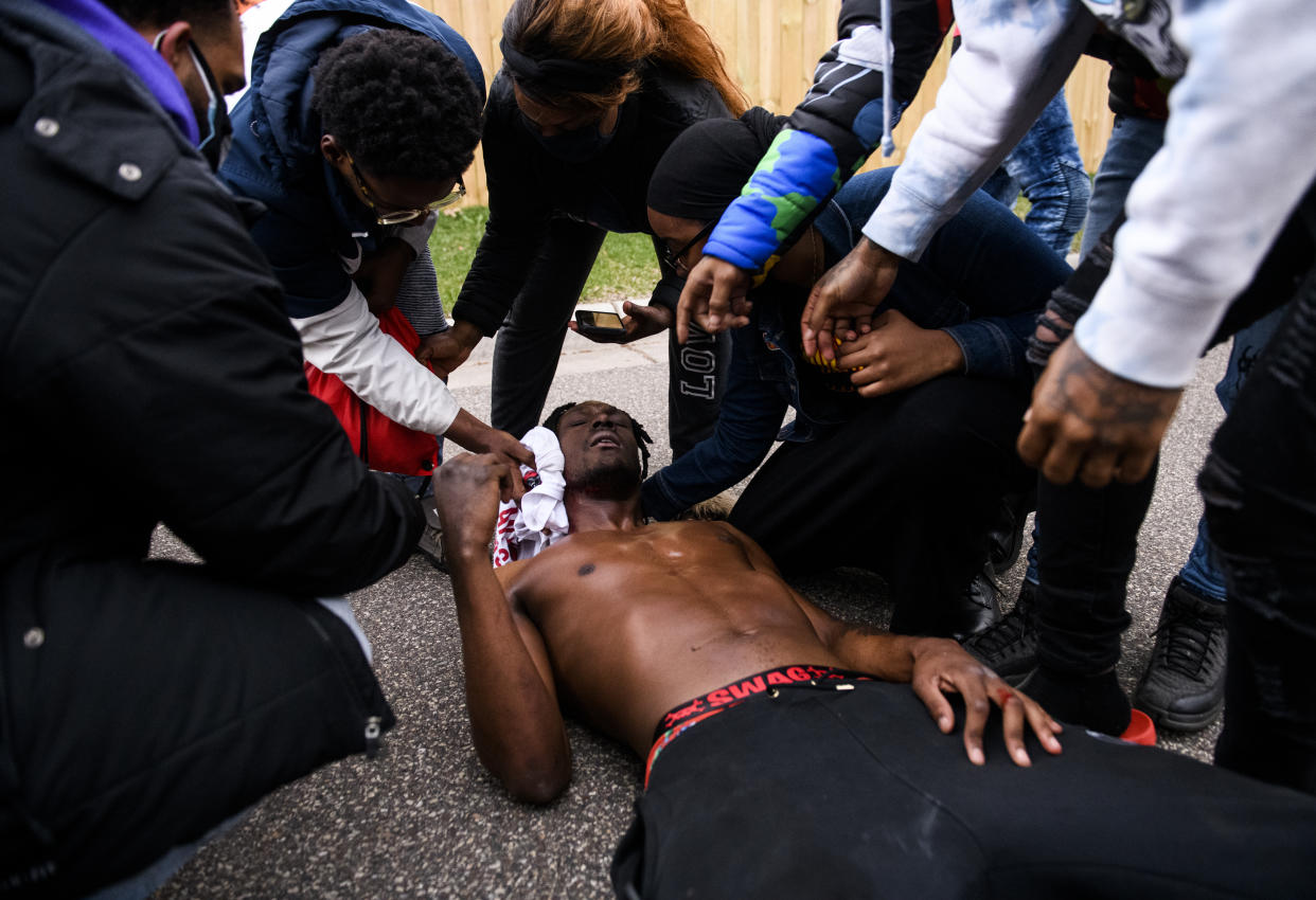 BROOKLYN CENTER, MN - APRIL 11: People treat a man who was shot in the neck with a projectile by police on April 11, 2021 in Brooklyn Center, Minnesota. Protesters took to the streets today after 20 year old Daunte Wright was shot and killed during a traffic stop by members of the Brooklyn Center police. (Photo by Stephen Maturen/Getty Images)