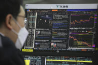 A screen shows a news report about U.S. President Joe Biden's inauguration as a currency trader works at the foreign exchange dealing room of the KEB Hana Bank headquarters in Seoul, South Korea, Thursday, Jan. 21, 2021. (AP Photo/Ahn Young-joon)