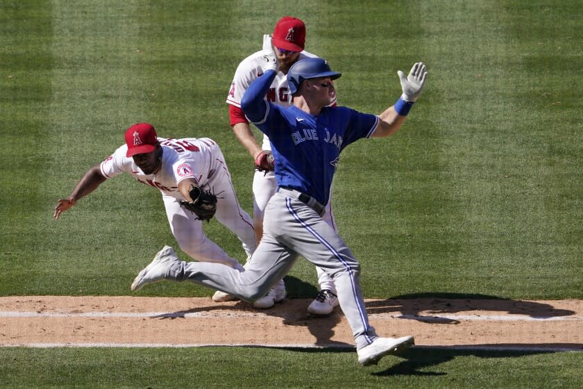Toronto Blue Jays' Matt Chapman, right, avoids a tag by Los Angeles Angels relief pitcher Oliver Ortega.