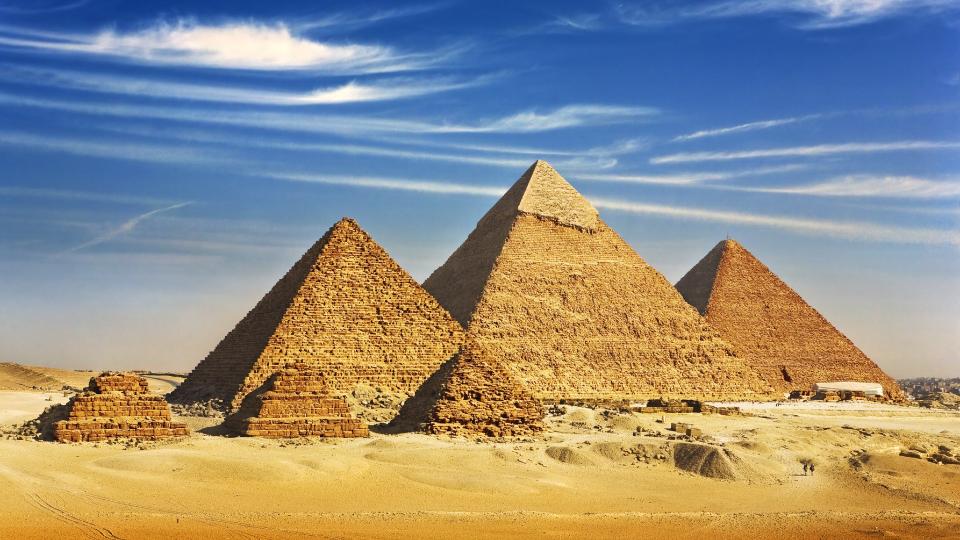 View of pyramids from the Giza Plateau (three pyramids known as Queens' Pyramids on front side; next in order from left - the Pyramid of Menkaure, Khafre and Khufu. WitR via Shutterstock