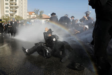 Israeli ultra-Orthodox Jewish men are sprayed with water during clashes with police at a protest against the detention of a member of their community who refuses to serve in the Israeli army, in Jerusalem September 17, 2017 REUTERS/Ronen Zvulun