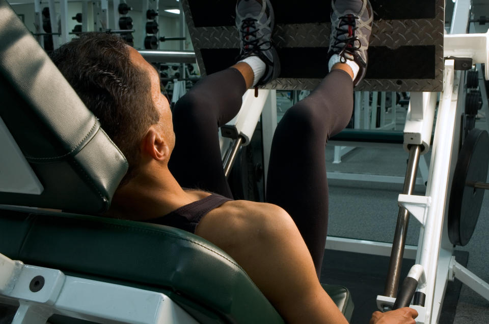 Person exercising on a leg press machine at the gym