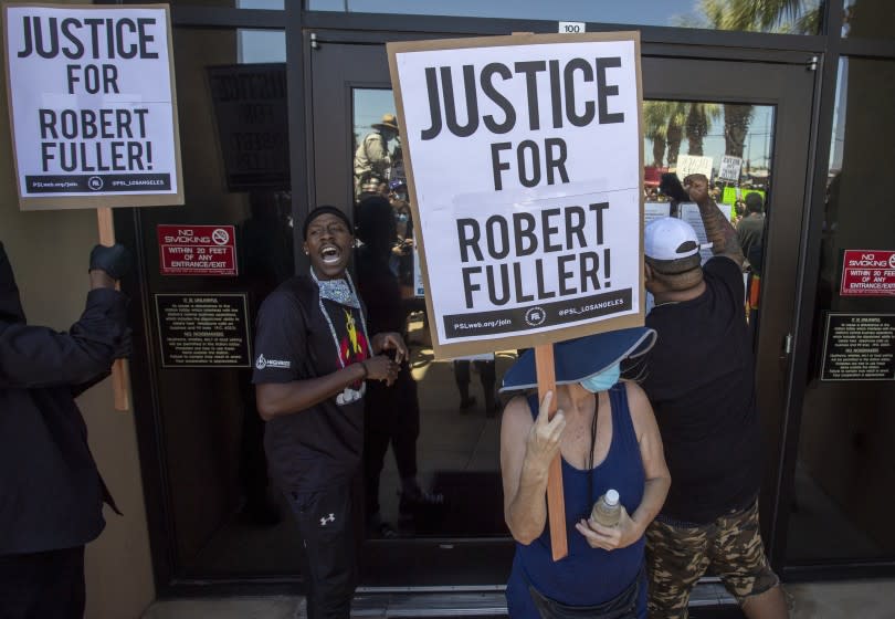 PALMDALE, CA - JUNE 13: Demonstrators knock at the front doors of the Los Angeles County Sheriff's Department's Palmdale Station on Saturday to demand justice the death of a young Black man, Robert Fuller, during a protest march on Saturday, June 13, 2020 in Palmdale, CA. (Brian van der Brug / Los Angeles Times)