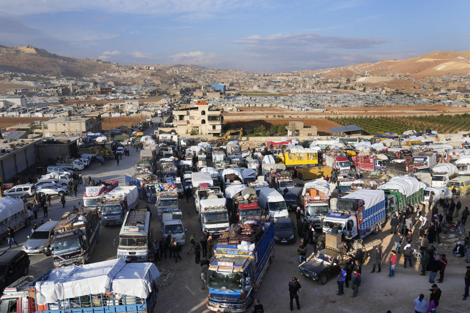 Trucks full of Syrian refugees belongings, wait at a gathering point to cross the border back home to Syria, in the eastern Lebanese border town of Arsal, Lebanon, Wednesday, Oct. 26, 2022. Several hundred Syrian refugees boarded a convoy of trucks laden with mattresses, water and fuel tanks, bicycles – and, in one case, a goat – Wednesday morning in the remote Lebanese mountain town of Arsal in preparation to return back across the nearby border.(AP Photo/Hussein Malla)