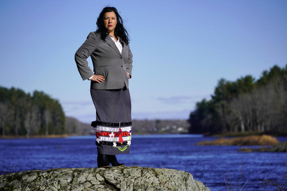 Dawn Neptune Adams stands on the banks of the Penobscot River, Tuesday, Nov. 23, 2021, on Indian Island, Maine. When Adams was a child she was one of the many Penobscot and Passamaquoddy people who were removed from their homes by the state of Maine and placed with white foster families. She recently co-directed a film that focuses on the Phips Proclamation of 1755, one of the dozens of government-issued bounty proclamations that directed colonial settlers to hunt, scalp and kill Indigenous people for money. (AP Photo/Robert F. Bukaty)