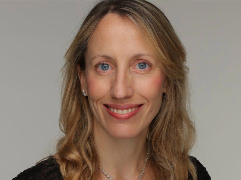 Caroline Malcolm, Chainalysis' global head of policy, wearing a black lace blouse in front of a gray background.