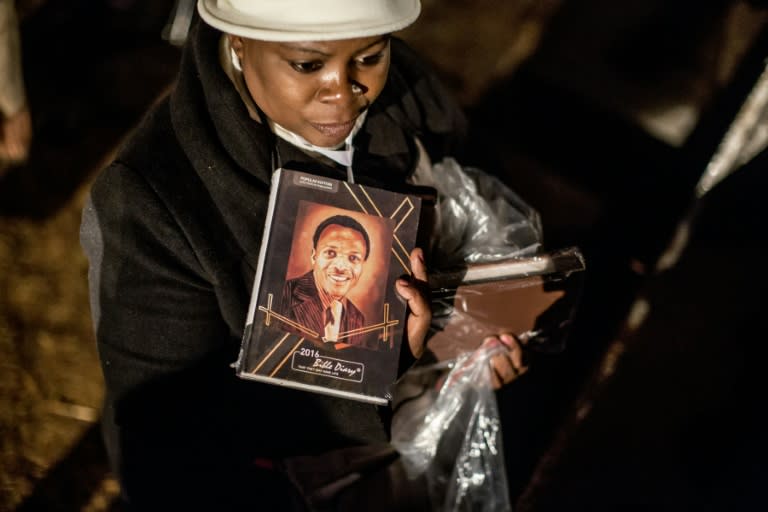 A South African worshipper holds a book bearing a portrait of Benedict Daswa as she attends a vigil in Thohoyandou, on the eve of his beatification ceremony on on September 12, 2015