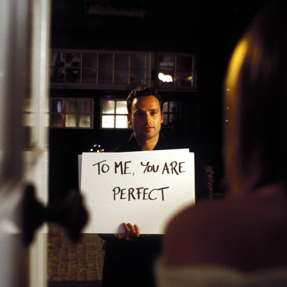 A man holds a sign reading 