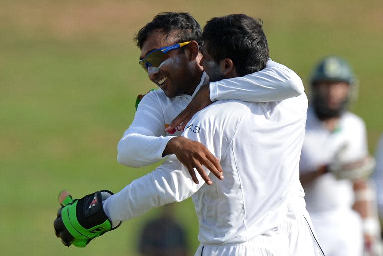 Sri Lanka's Mahela Jayawardene (L) and wicketkeeper Niroshan Dickwella celebrate the dismissal of South Africa's Faf du Plessis during the second day of the second Test in Colombo on July 25, 2014