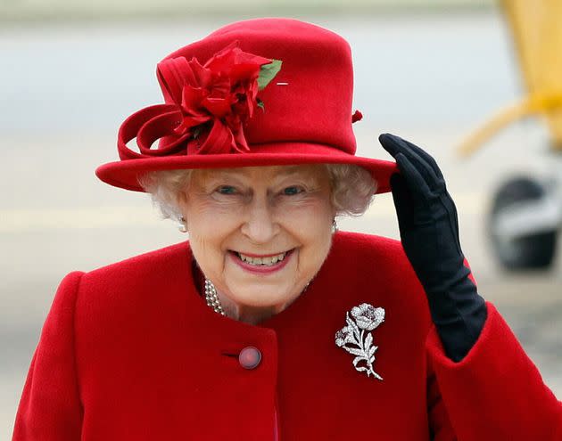 Queen Elizabeth II holds on to her hat in high winds as she arrives for a visit to RAF Valley in Anglesey, Wales on April 1, 2011. (Photo: Christopher Furlong/Pool/AFP via Getty Images)