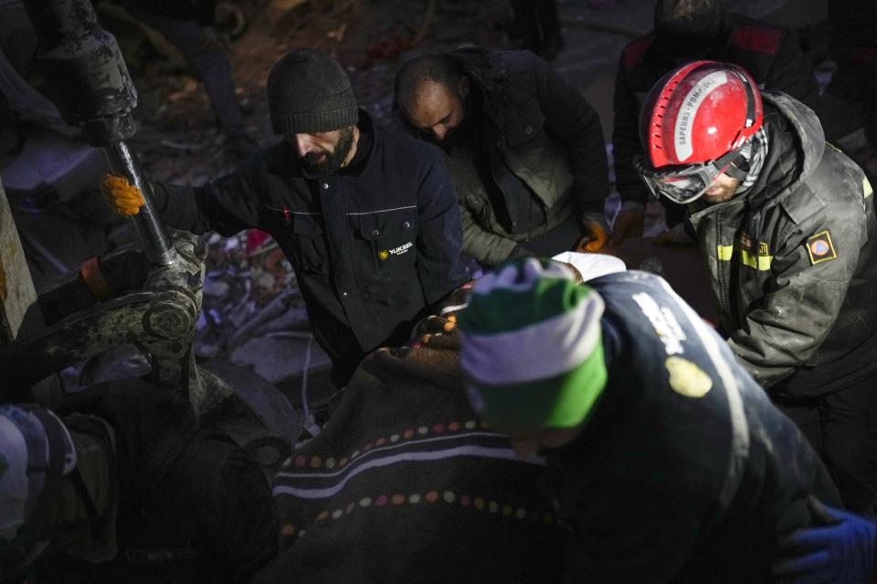 <p>Lebanese rescue team members carry the body of a woman found among rubble in a destroyed building in Elbistan, southern Turkey, Wednesday, Feb. 8, 2023. With the hope of finding survivors fading, stretched rescue teams in Turkey and Syria searched Wednesday for signs of life in the rubble of thousands of buildings toppled by a catastrophic earthquake. (AP Photo/Francisco Seco)</p> 