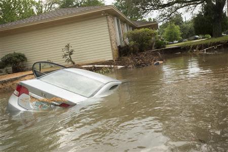 A submerged car sits in the driveway in the Cordova Park neighborhood in Pensacola, Florida, April 30, 2014. REUTERS/Michael Spooneybarger