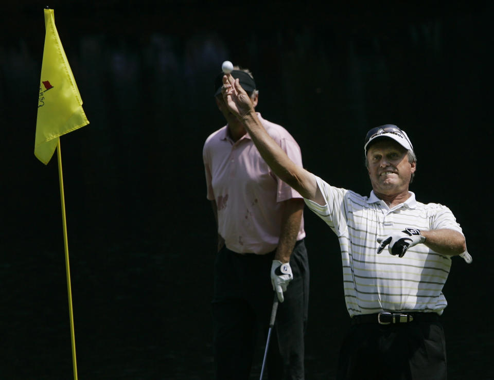 FILE - Wayne Grady throws his ball to the gallery after making a hole-in-one on the ninth hole in the par three tournament prior to the 2008 Masters golf tournament at the Augusta National Golf Club in Augusta, Ga., USA on April 9, 2008. Greg Norman's involvement in the Saudi Arabian-backed LIV golf tour and comments he's made about the killing of Washington Post columnist Jamal Khashoggi at a Saudi consulate in Turkey are being questioned by other Australian golfers. (AP Photo/Morry Gash, File)