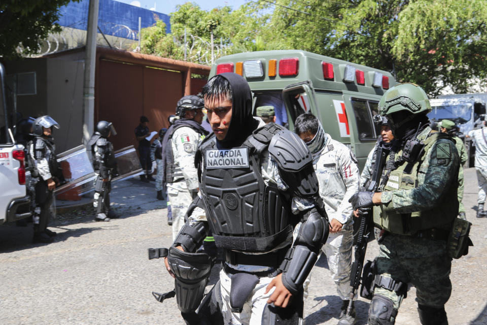 An injured National Guard soldier walks away for treatment amid clashes with students from a rural teachers' college protesting the previous week's shooting of one of their colleagues during a confrontation with police, outside the state's Attorney General's Office in Chilpancingo, Mexico, Tuesday, March 12, 2024. (AP Photo/Alejandrino Gonzalez)