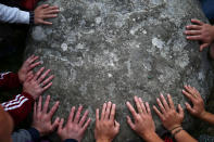 <p>People touch the stones of the Stonehenge monument at dawn on the summer solstice near Amesbury, Britain, June 21, 2017. (Photo: Neil Hall/Reuters) </p>